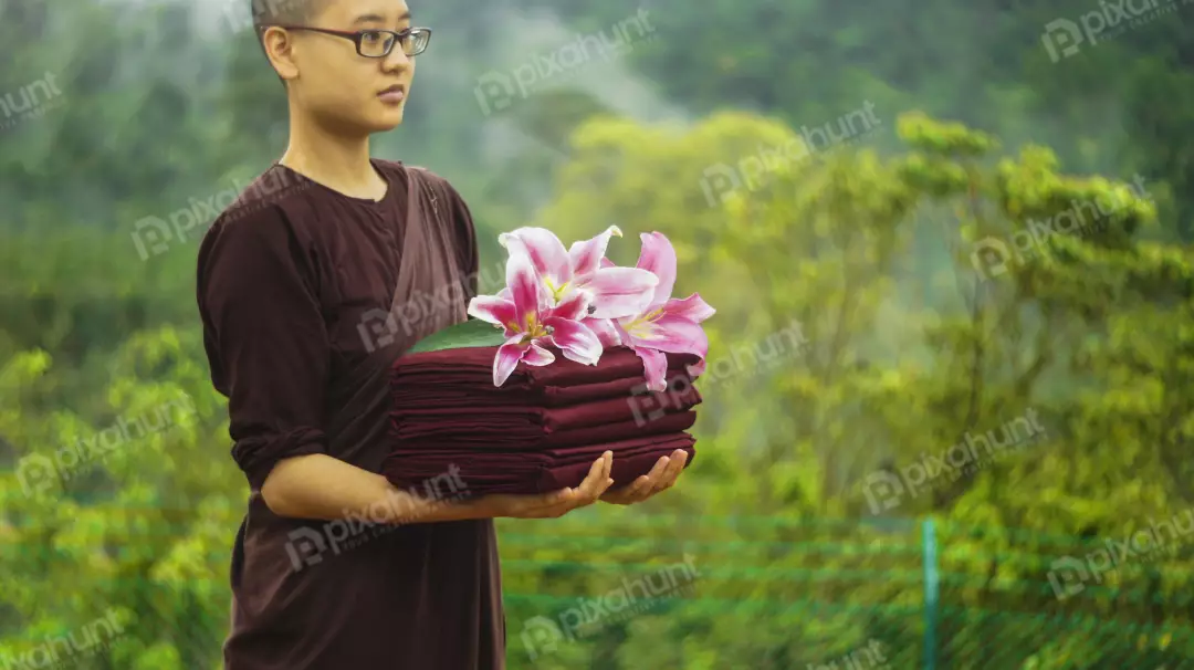 Free Premium Stock Photos Monk Holding A Stack Of Red Cloths With Flower
