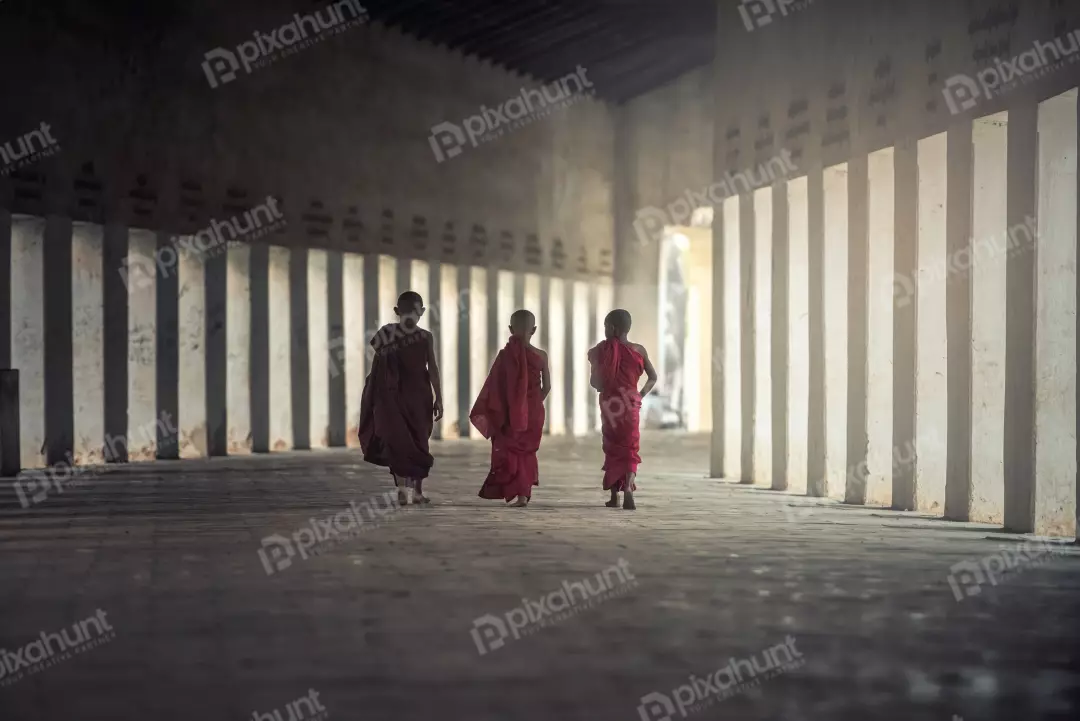 Free Premium Stock Photos Three monks walking away from the camera and wearing traditional robes and are walking barefoot