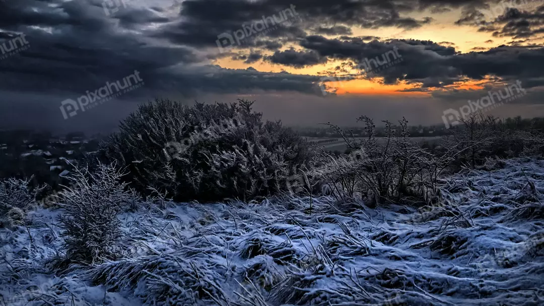 Frosted Winter Terrain Under a Dramatic Sunset Horizon
