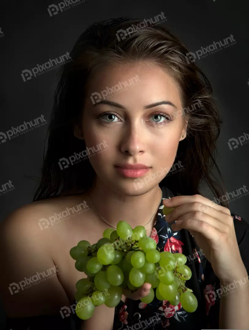 Captivating Young Woman Posing with Fresh Green Grapes