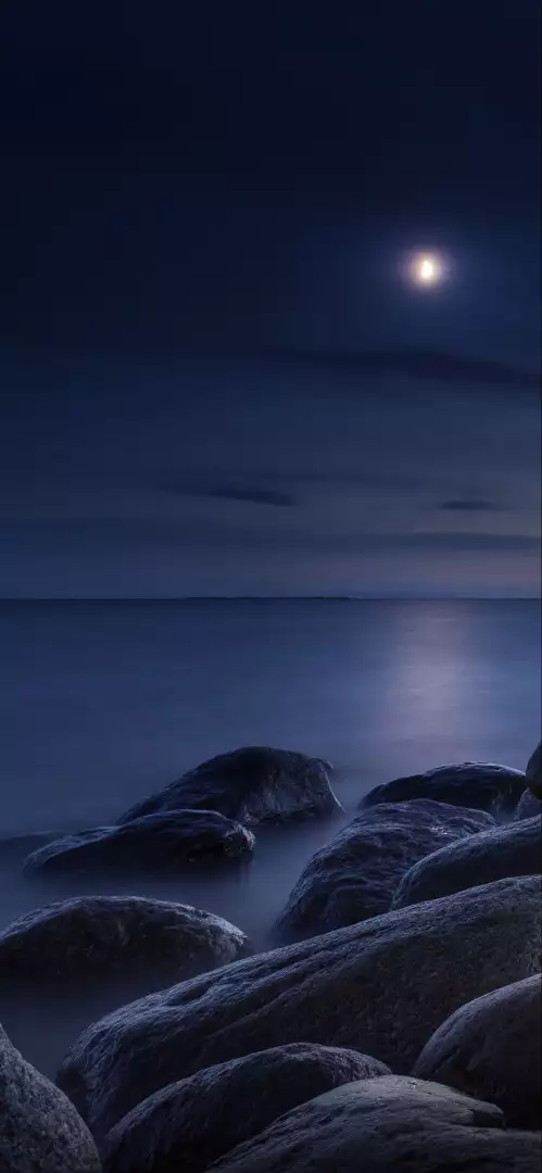 Free Premium Stock Photos Moonlit Rocky Shoreline with Calm Ocean and Distant Horizon at Night