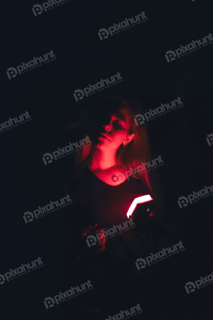 Free Premium Stock Photos Mesmerizing female portrait illuminated by vibrant red glow and deep shadows