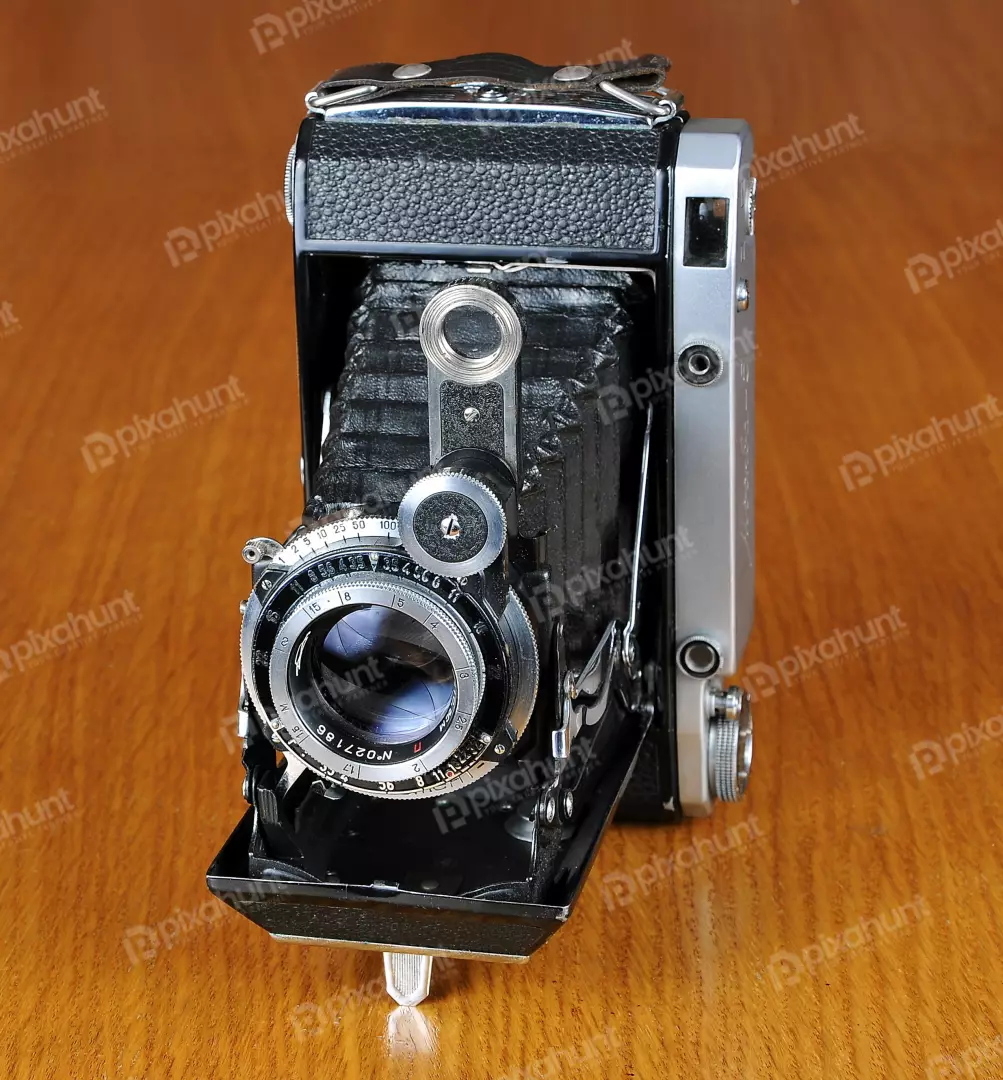 Classic Vintage Folding Camera with Bellows on Wooden Table