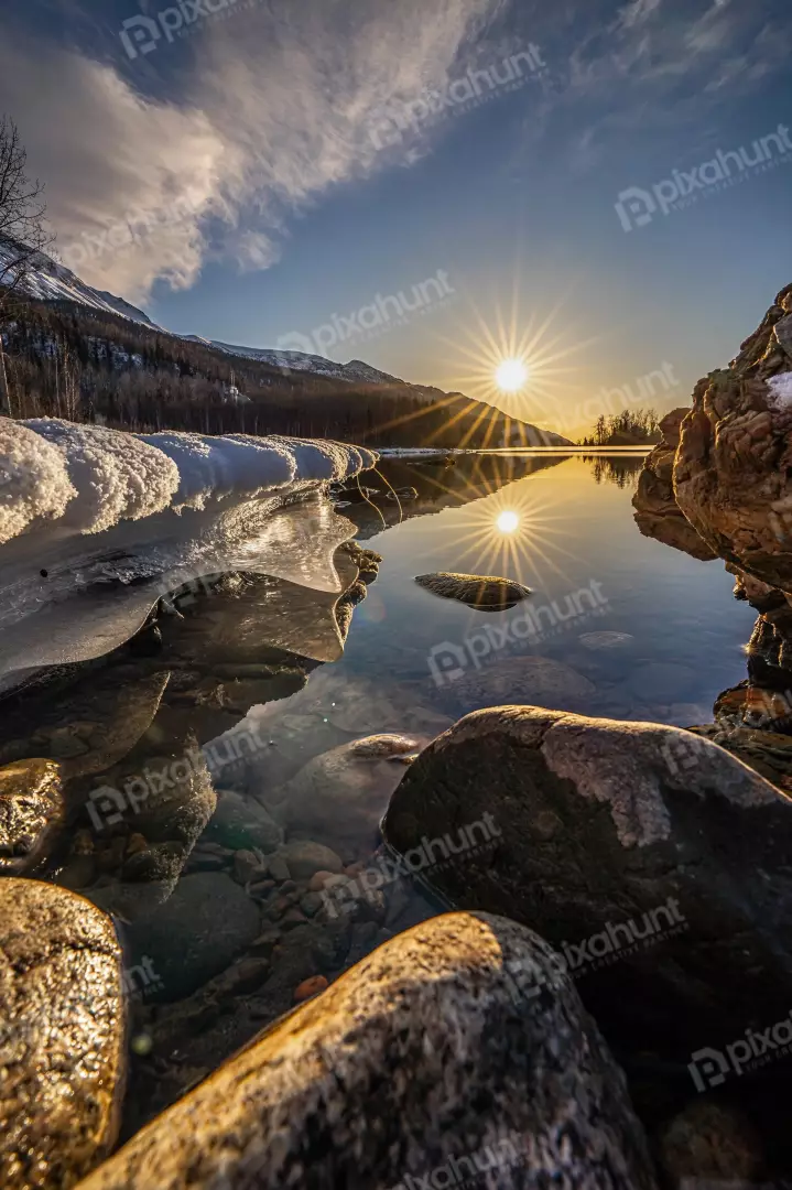 Free Premium Stock Photos Breathtaking winter sunrise over a frozen lake with sunburst reflection