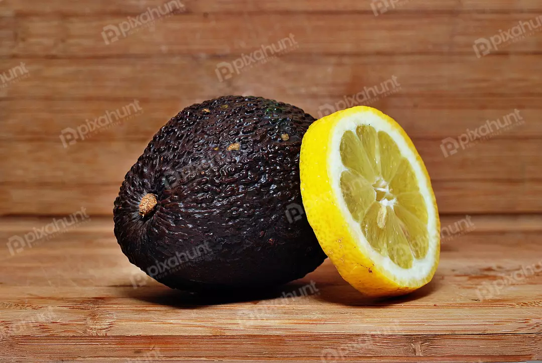 Fresh Ripe Avocado and Zesty Lemon Slice on Rustic Wooden Board