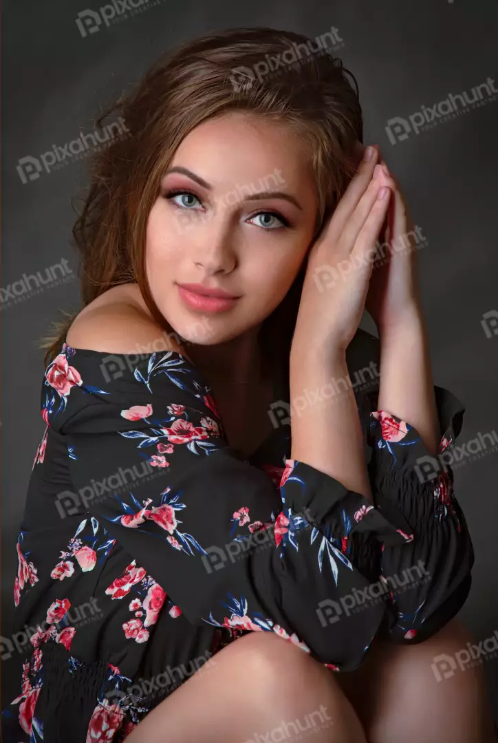 Pensive Young Woman in Floral Dress, Hands Clasped Elegantly
