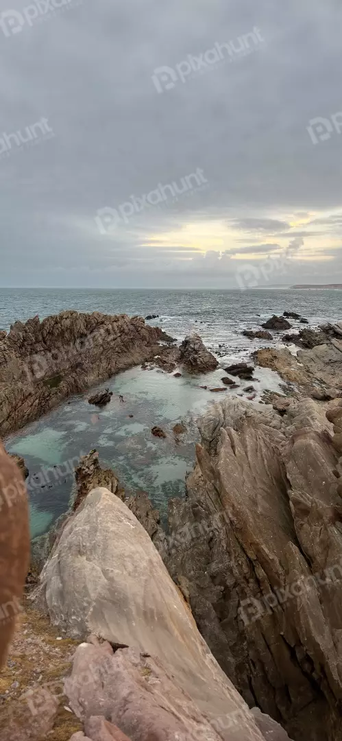Free Premium Stock Photos Rocky coastline with a natural tidal pool under a cloudy sky