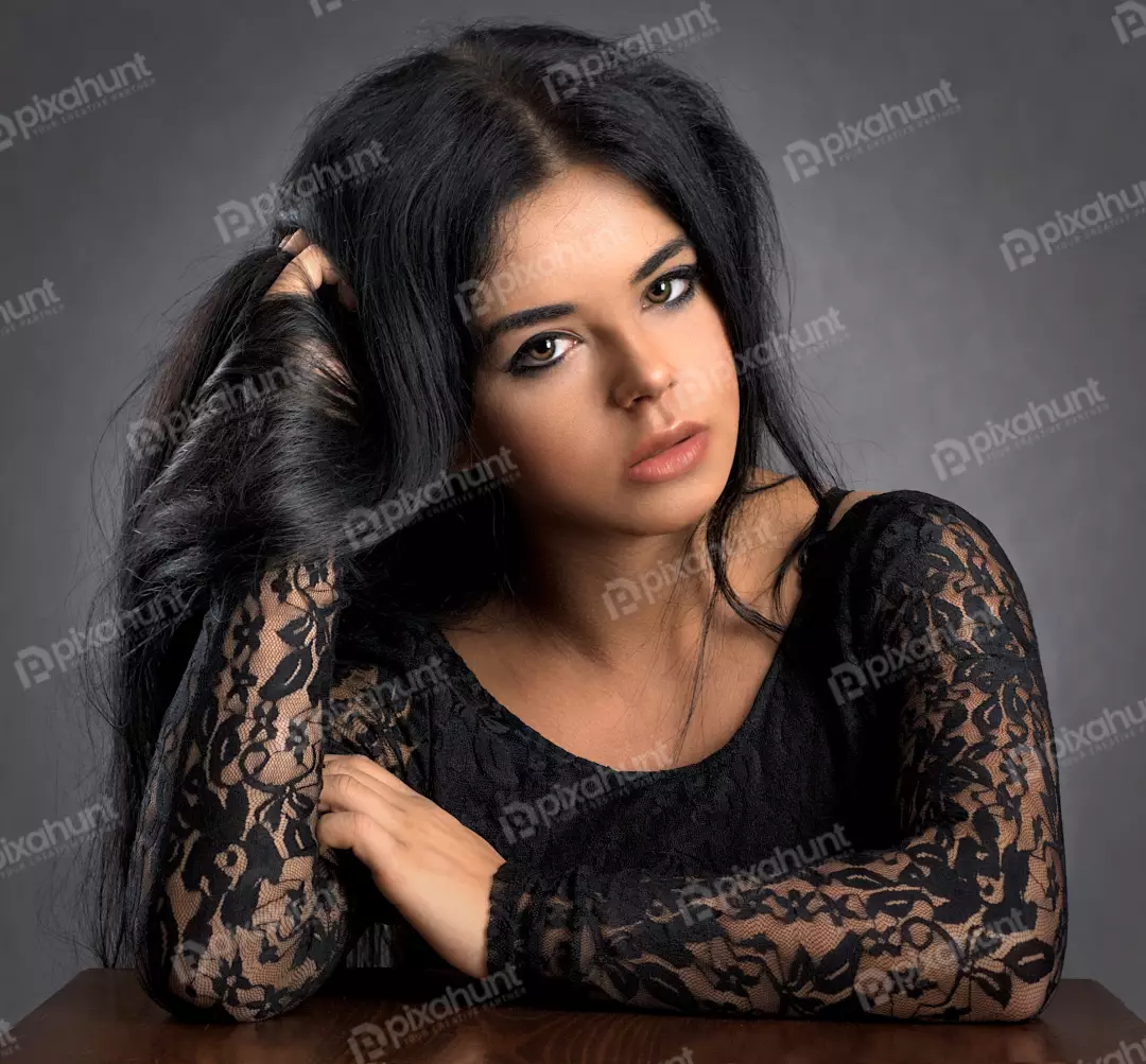 Pensive Young Woman in Black Lace Top with Long Dark Hair Studio Portrait