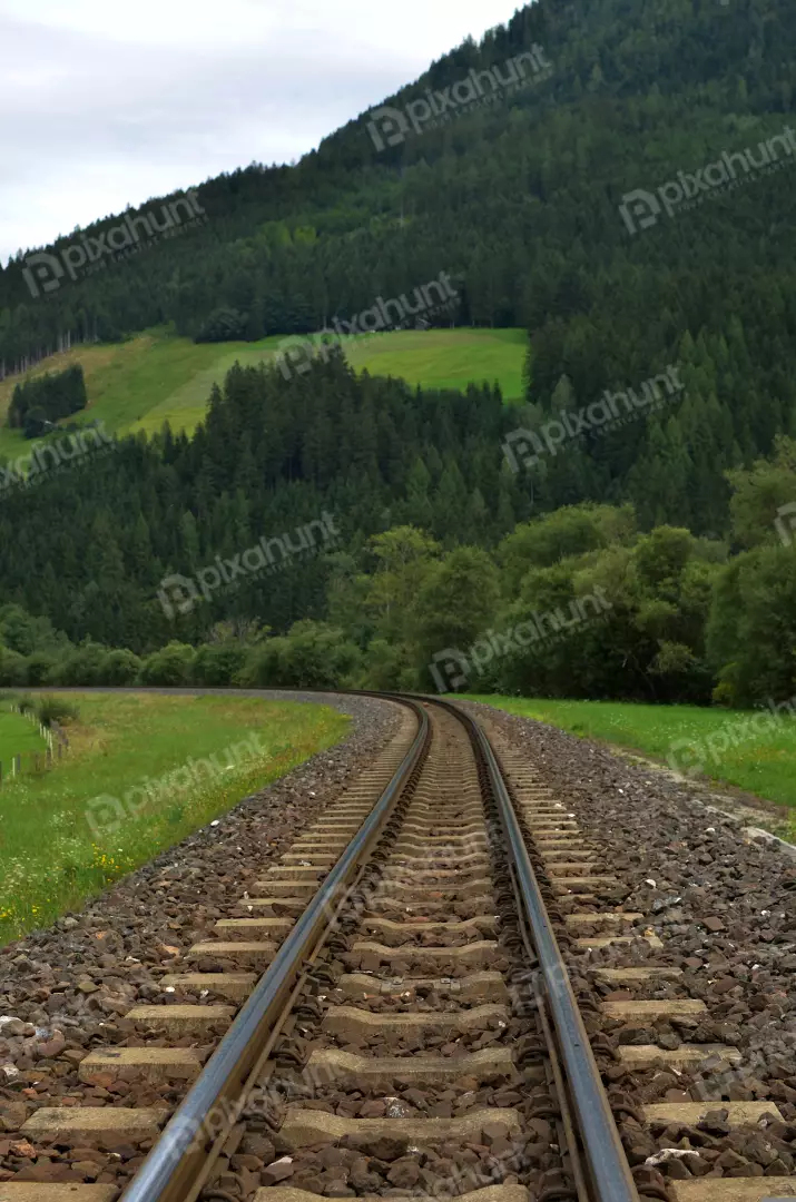 Curved Railway Tracks Through Lush Green Mountain Valley