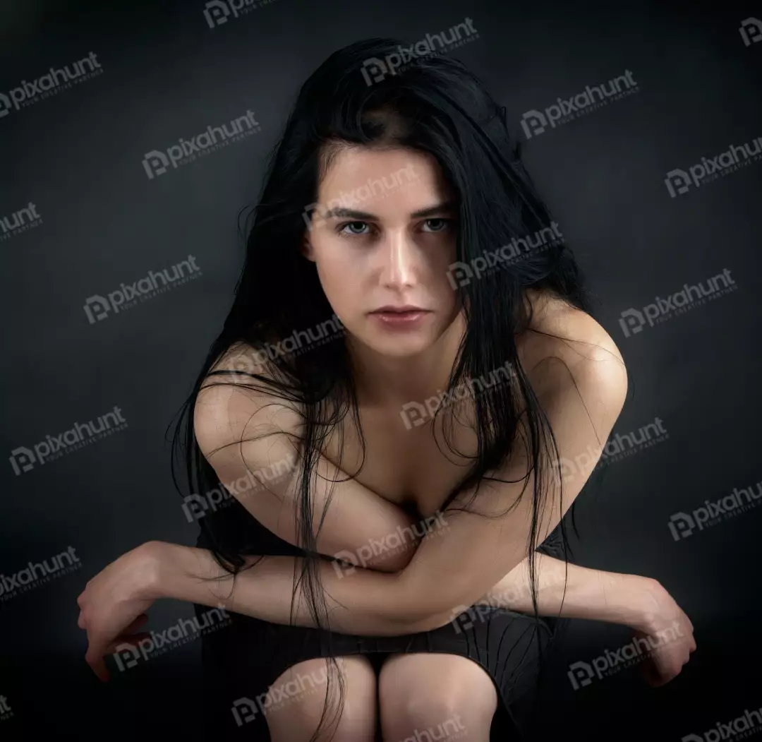 Pensive Young Woman with Intense Gaze, Long Dark Hair and Crossed Arms