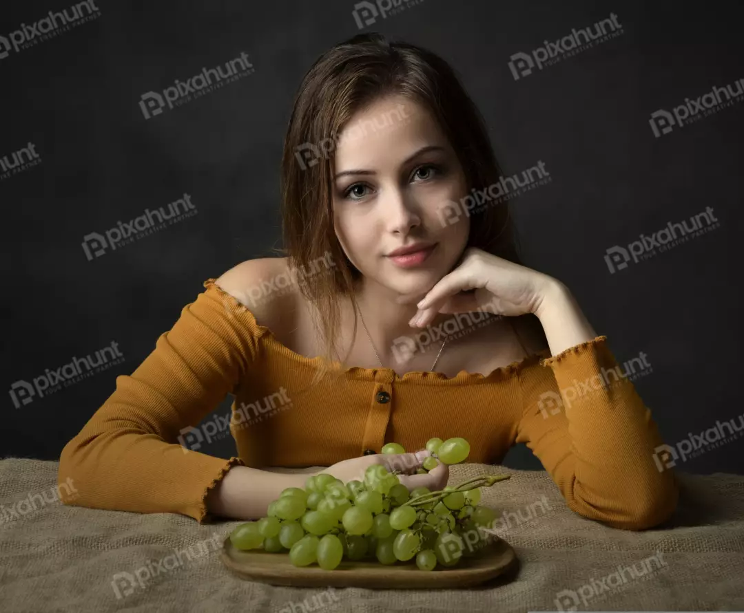 Captivating Young Woman Posing with Green Grapes for Healthy Lifestyle