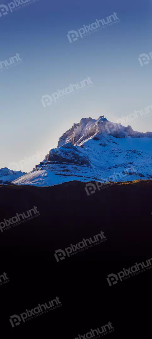 Free Premium Stock Photos Snow-capped mountain summit bathed in golden sunlight under a clear blue sky