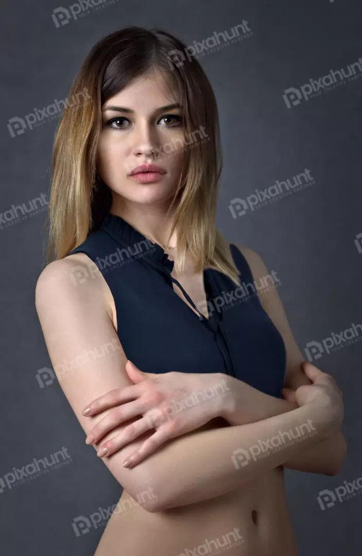 Elegant Young Woman with Ombre Hair, Crossed Arms, and Blue Sleeveless Top