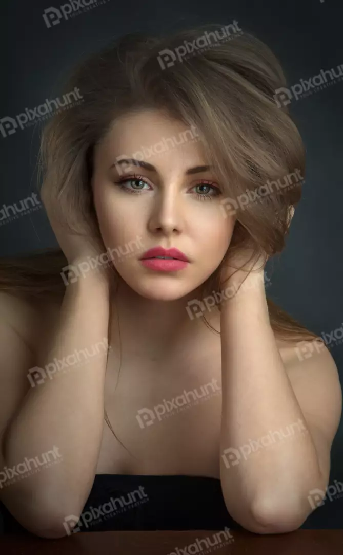 Young Woman with Expressive Gaze Posing with Hands on Head, Studio Portrait