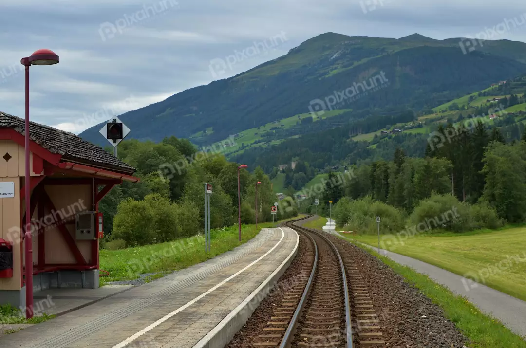 Scenic Alpine Railway Station Tracks Winding Through Green Mountains