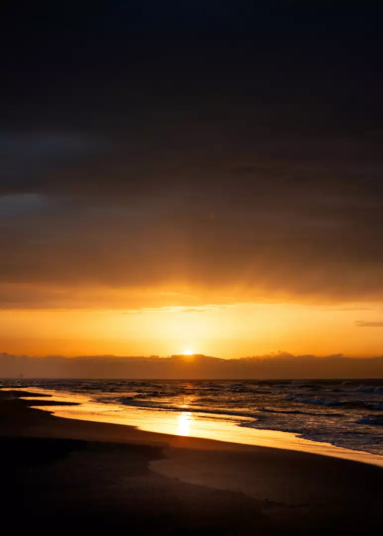 Free Premium Stock Photos Dramatic sunset over ocean waves and sandy beach with reflection