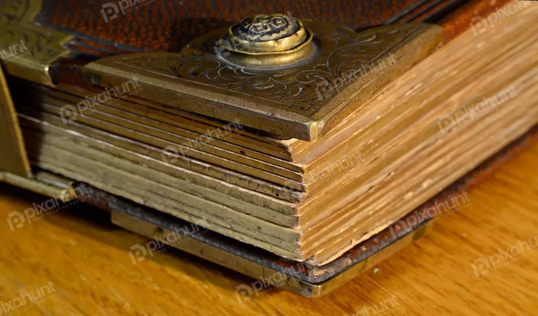 Antique Leather Book with Ornate Metal Clasp and Aged Pages on Wood