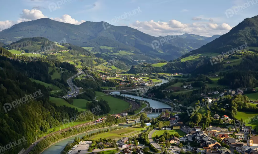 Panoramic European Alpine Valley with River, Highway, Train, and Village