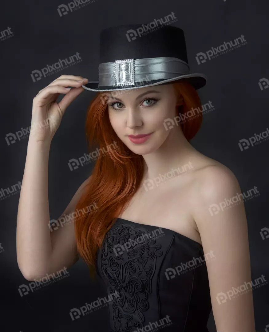 Confident Red-Haired Woman Adjusting Ornate Top Hat in Studio Portrait