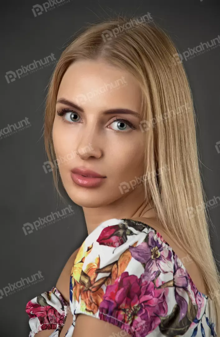 Captivating Blonde Woman in Floral Blouse with Expressive Blue Eyes