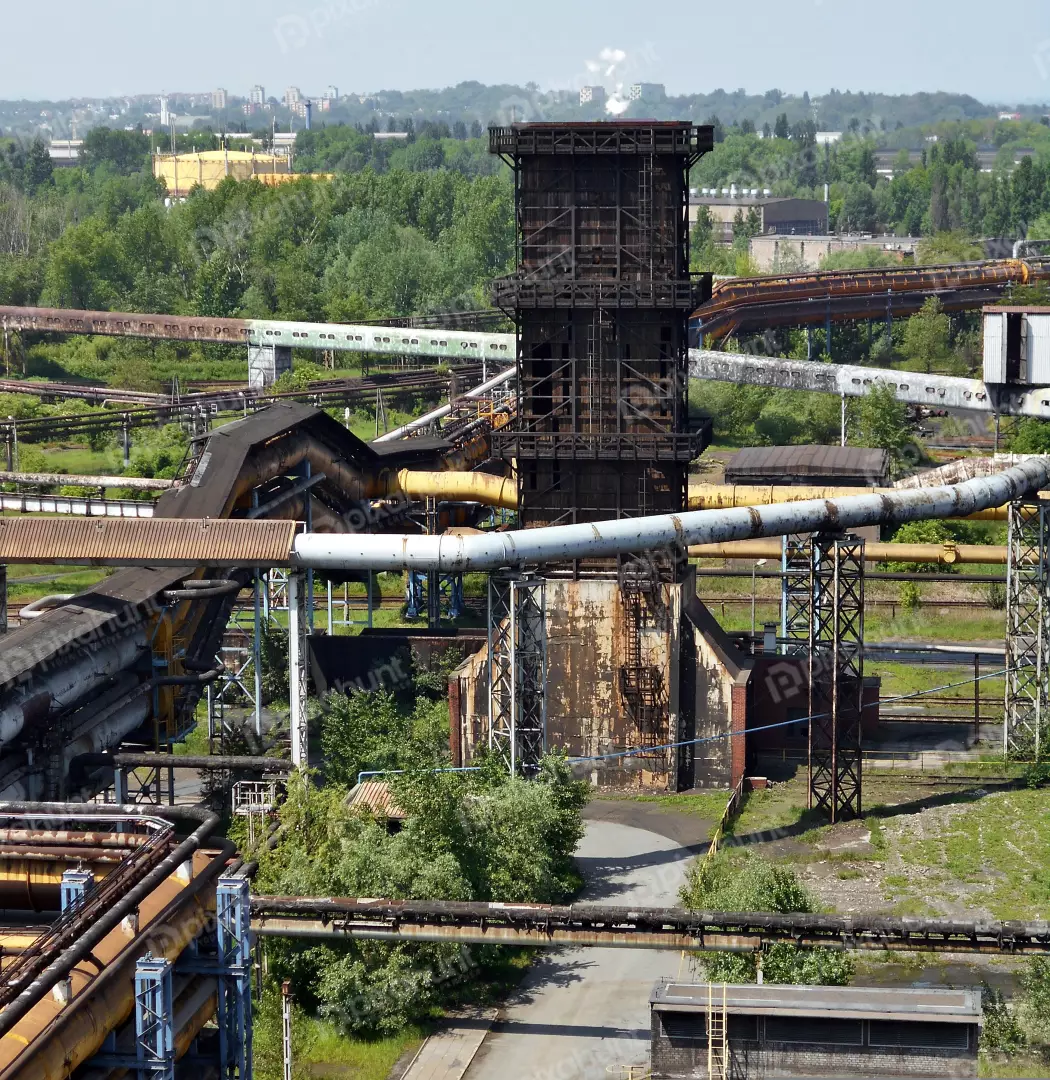 Aging Industrial Facility: Rusty Steel, Towering Structures, Lush Green Surroundings