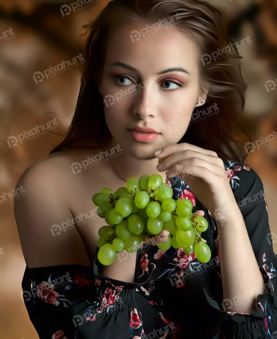 Young Woman Posing with Fresh Green Grapes, Elegant Floral Dress