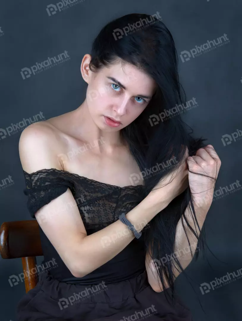 Captivating Young Woman with Striking Blue Eyes and Flowing Dark Hair Posing