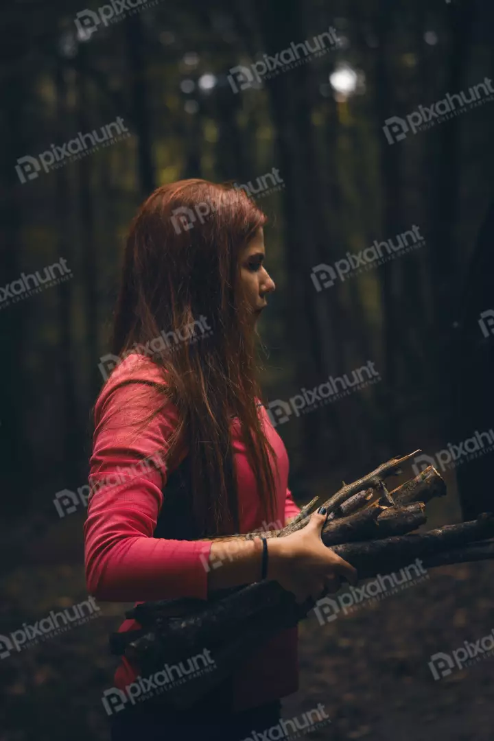 Free Premium Stock Photos Redhead Gathering Natural Wood Branches in a Serene, Deep Forest Environment