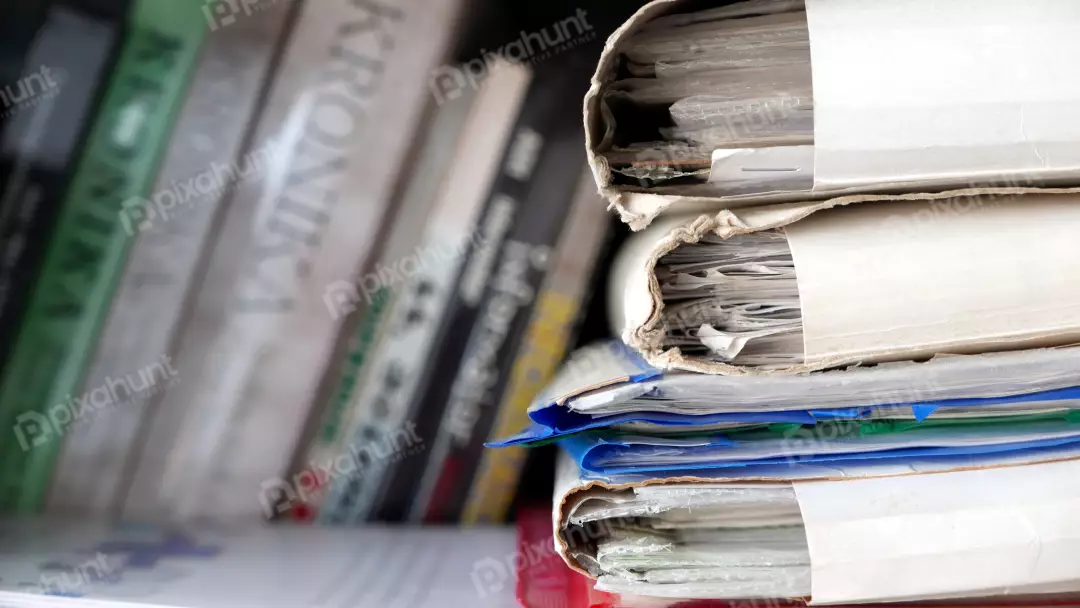 Aged Office Documents in Stacked Worn Binders on Shelf
