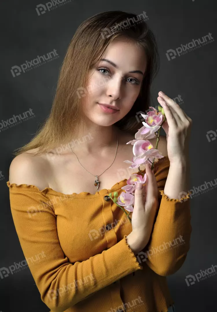Serene Young Woman with Green Eyes and Pink Orchid Branch