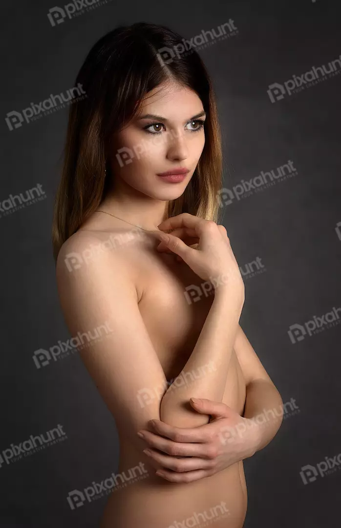 Sensual Portrait of Young Woman Posing Nude with Covered Chest in Studio