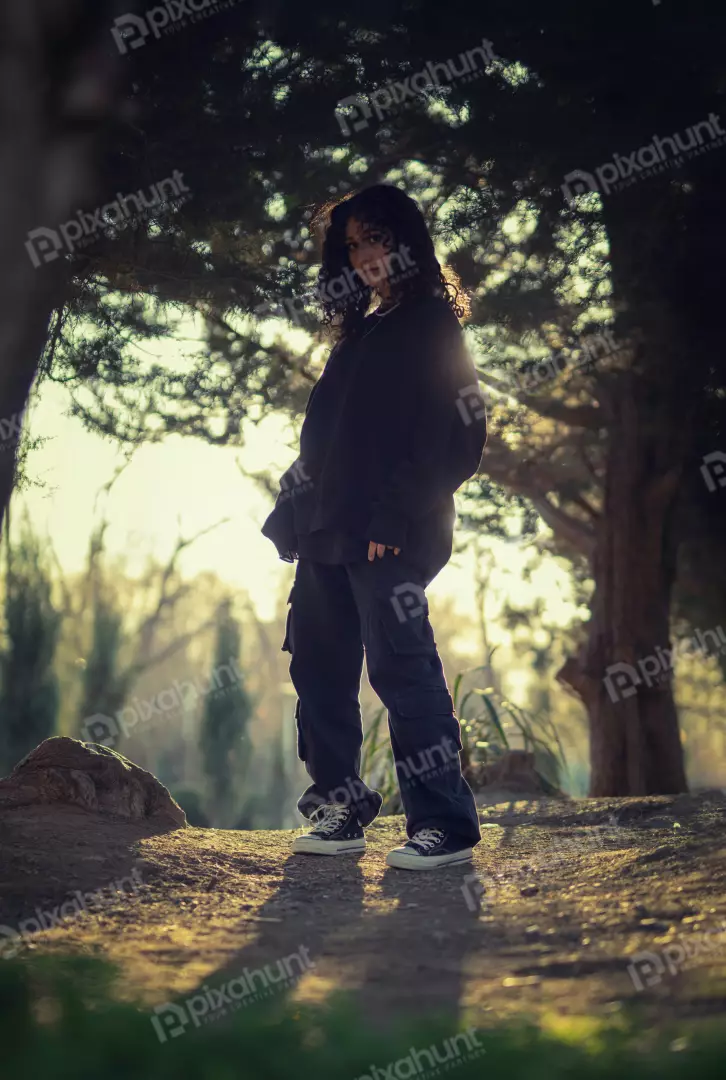 Free Premium Stock Photos Stylish Young Person in Oversized Hoodie and Cargo Pants Amidst Sunlit Trees