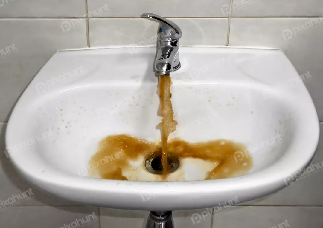 Rusty Tap Water Contaminating a White Bathroom Sink