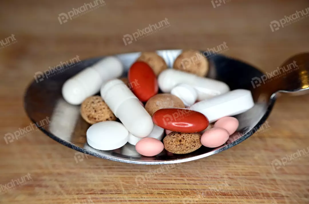 Assorted Medical Pills and Capsules on Silver Spoon for Healthcare