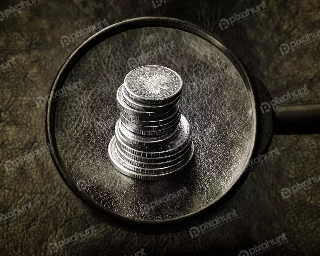 Magnifying Glass Examining Stack of Polish Zloty Coins on Dark Textured Background