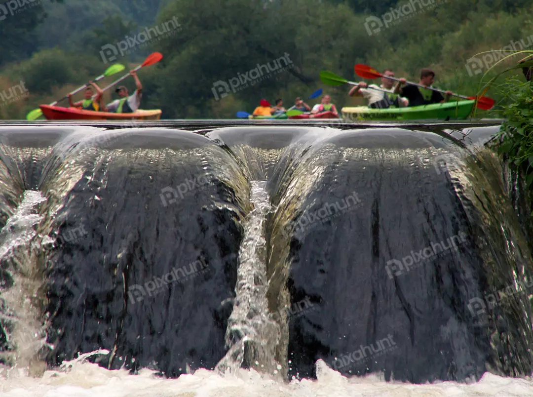 Kayakers Paddling Above a River Waterfall During a Summer Outdoor Adventure