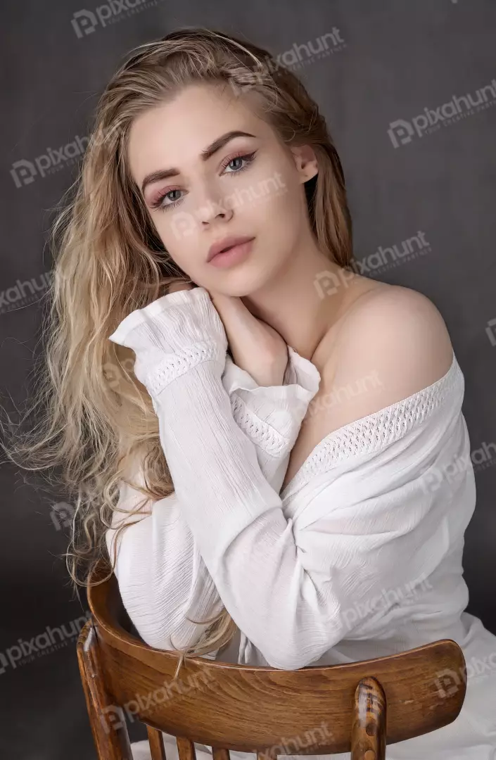 Blonde Woman in White Off-Shoulder Top Posing on Wooden Chair Studio Portrait