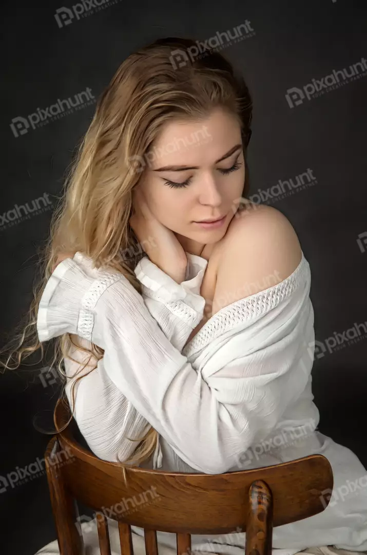 Contemplative Woman with Wavy Blonde Hair in White Off-Shoulder Top