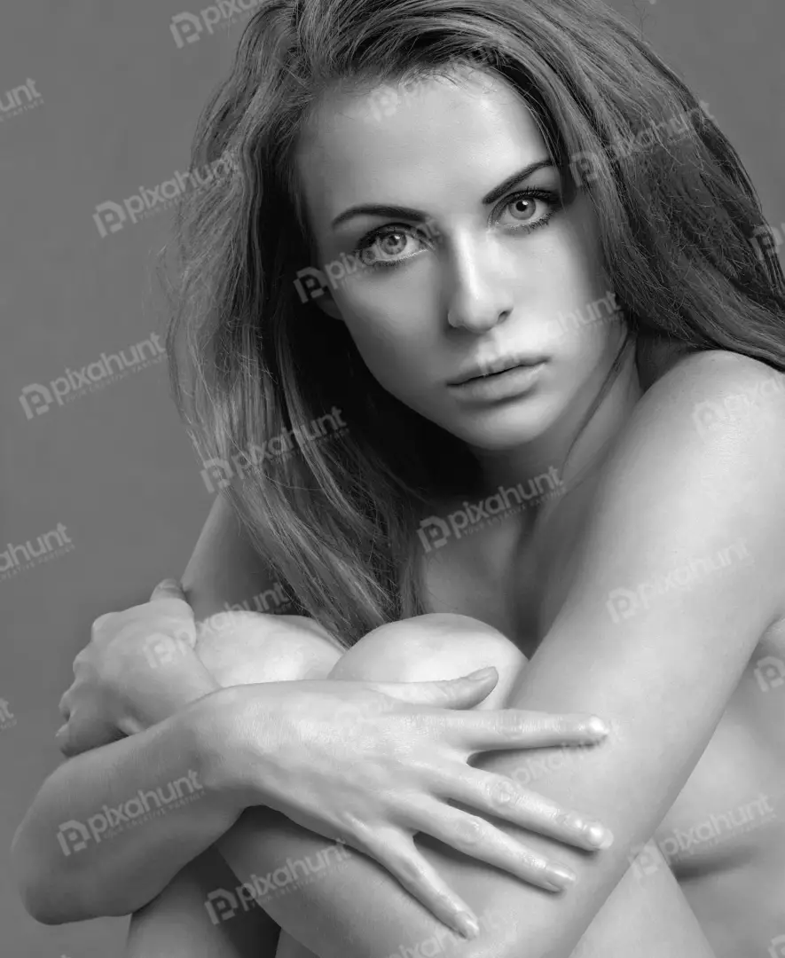 Artistic Black and White Portrait of a Pensive Young Woman Hugging Her Knees