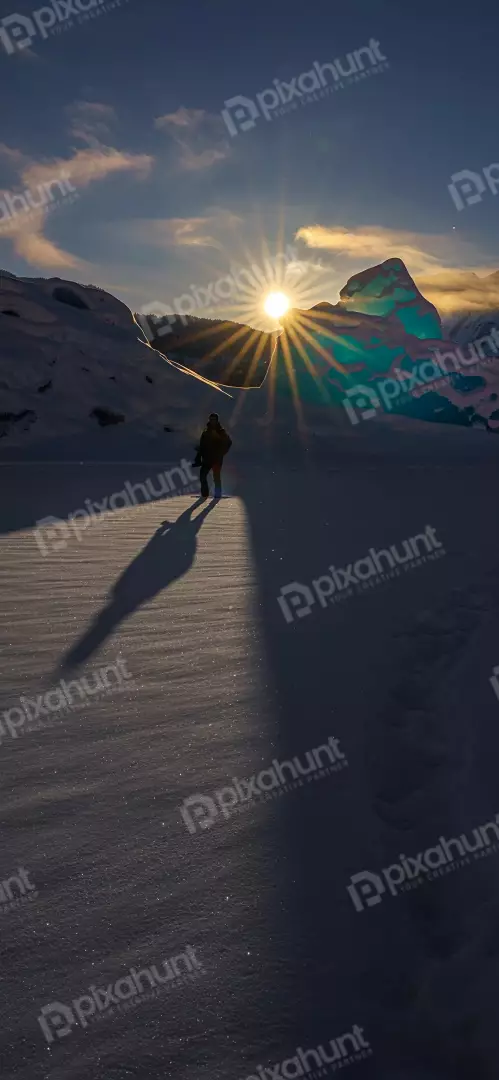 Free Premium Stock Photos Lone hiker walks towards sunburst in snowy glacial landscape