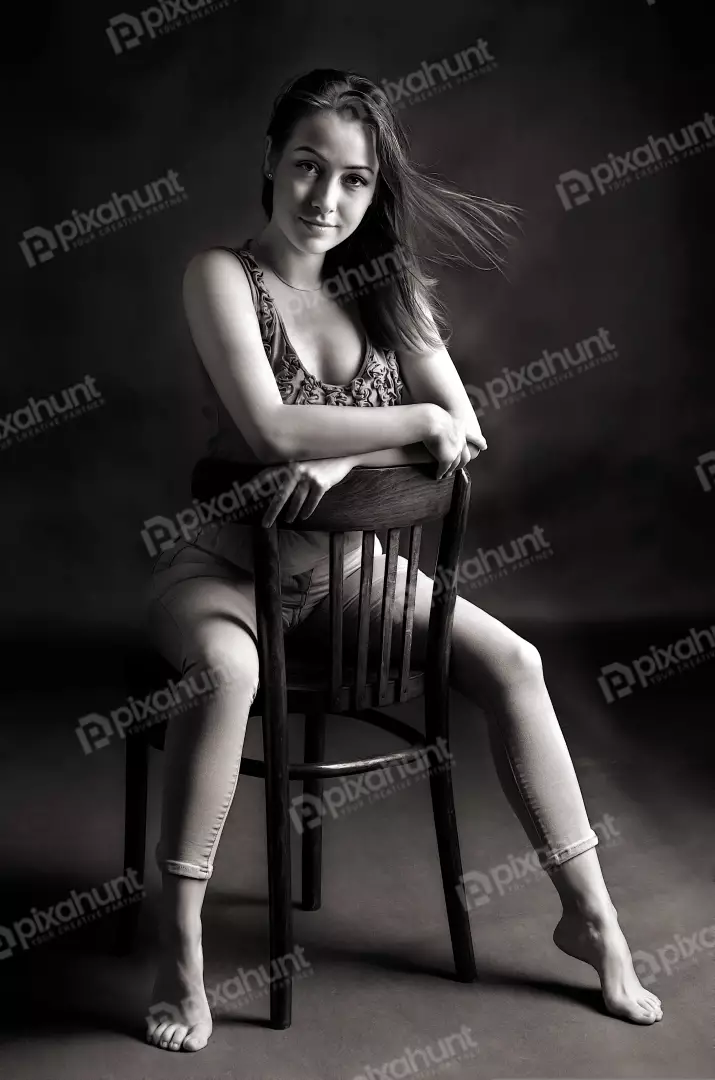 Monochrome Seated Portrait of Woman with Windswept Hair and Elegant Pose