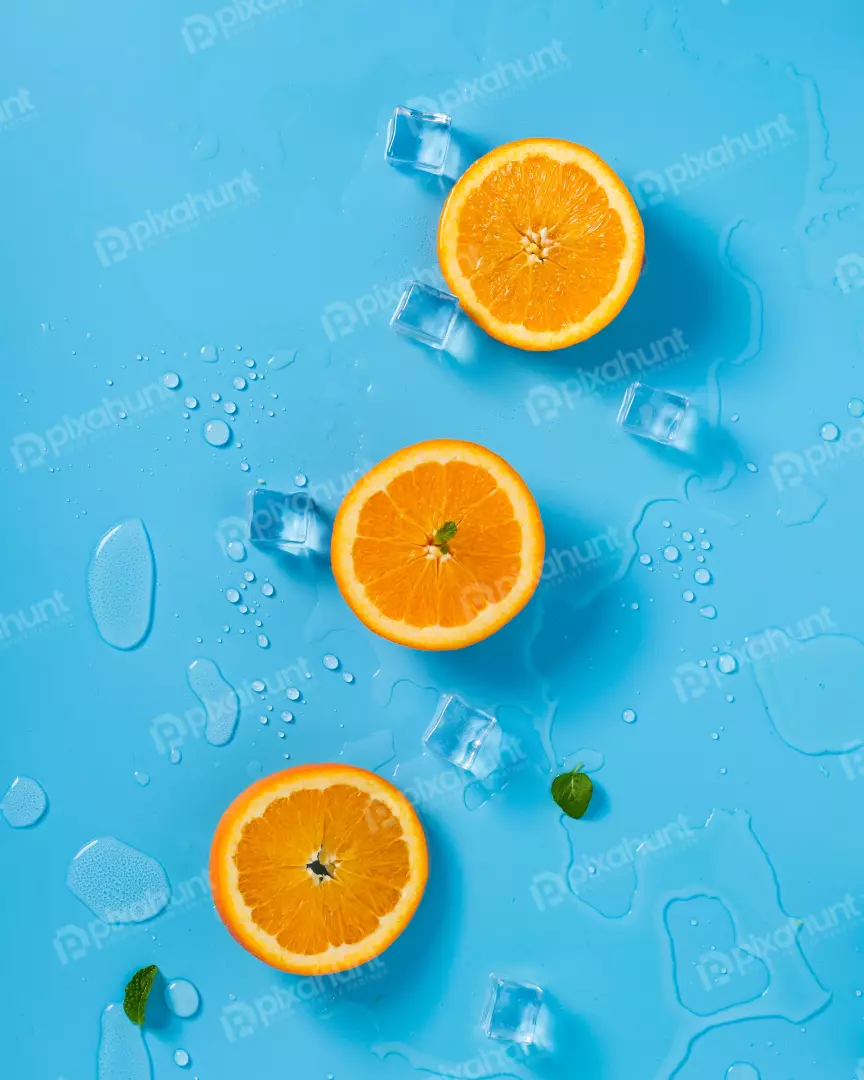 Free Premium Stock Photos Refreshing Orange Slices with Ice Cubes and Mint Leaves on Blue Surface