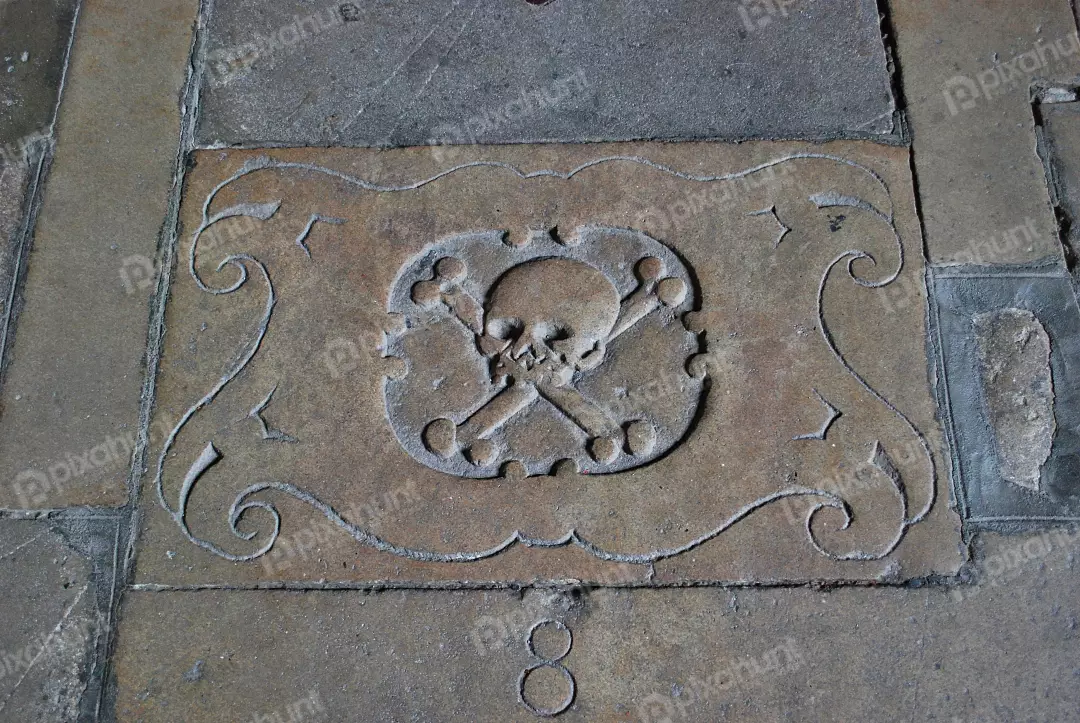 Ancient Skull and Crossbones Carving on Historic Stone Floor Texture
