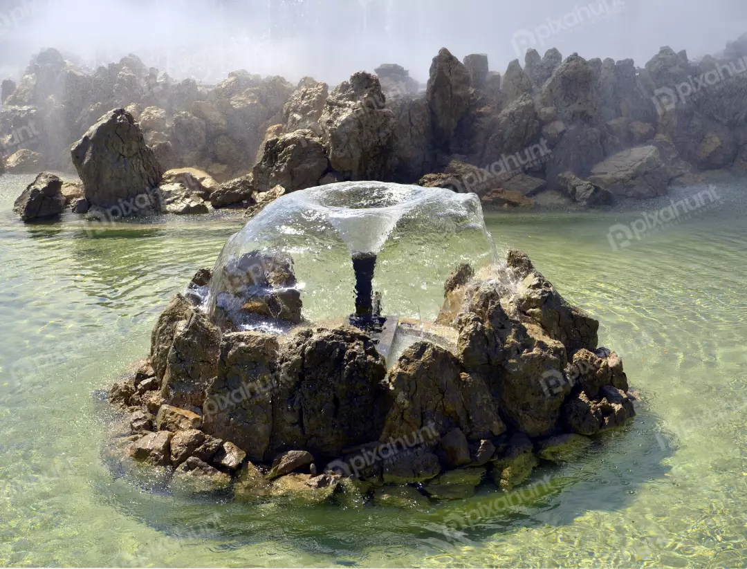 Natural Stone Fountain with Dynamic Water Spray in Clear Green Lake