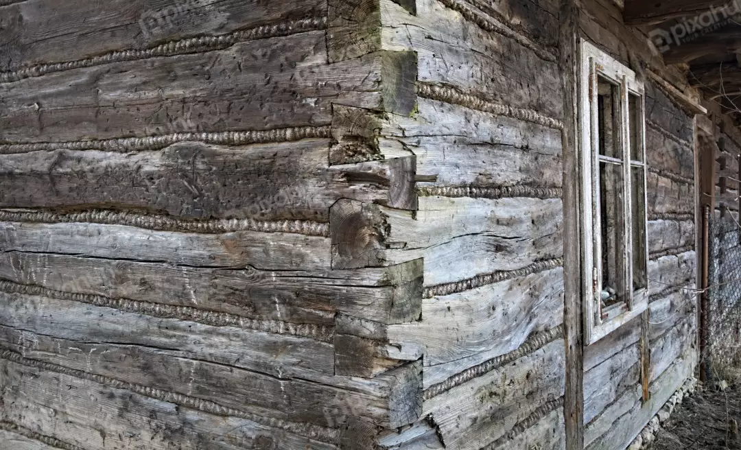 Rustic Weathered Wooden Log Cabin Corner with Traditional Chinking and Old Window Frame