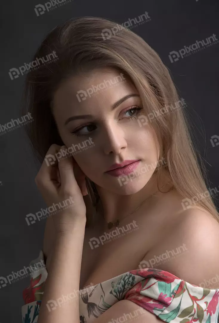 Elegant Young Woman with Pensive Gaze, Floral Off-Shoulder Dress, Gold Necklace