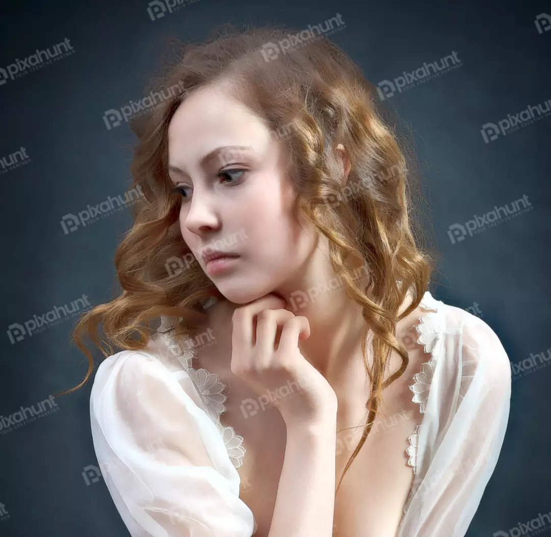 Graceful Young Woman with Thoughtful Expression and Wavy Auburn Hair in Soft Light