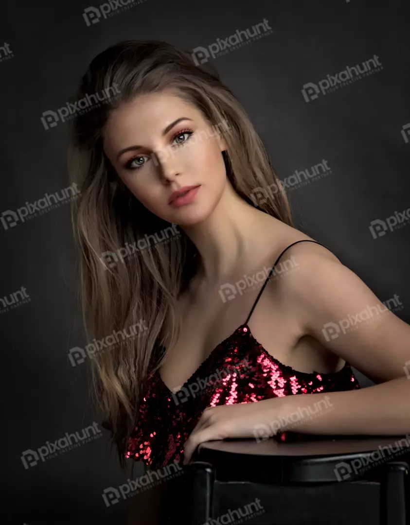 Glamorous Young Woman Posing in Shimmering Red Sequin Top