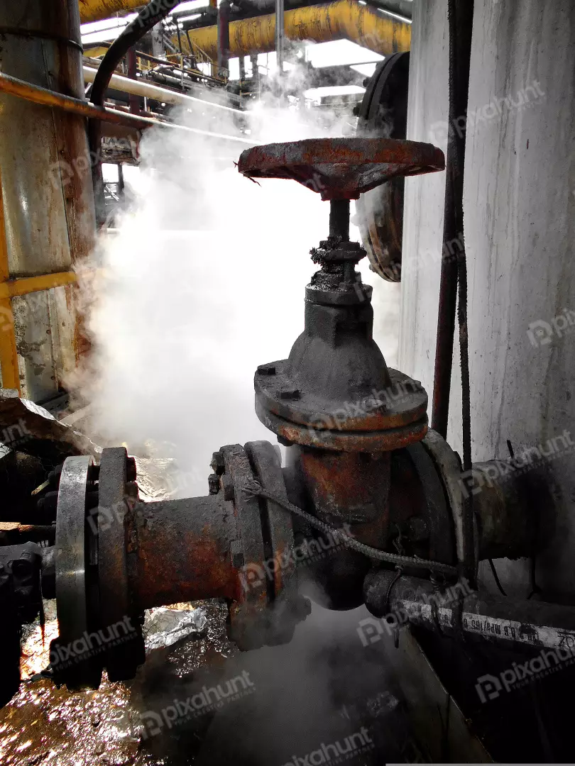 Rusty Industrial Valve Leaking Steam in a Dilapidated Factory Setting