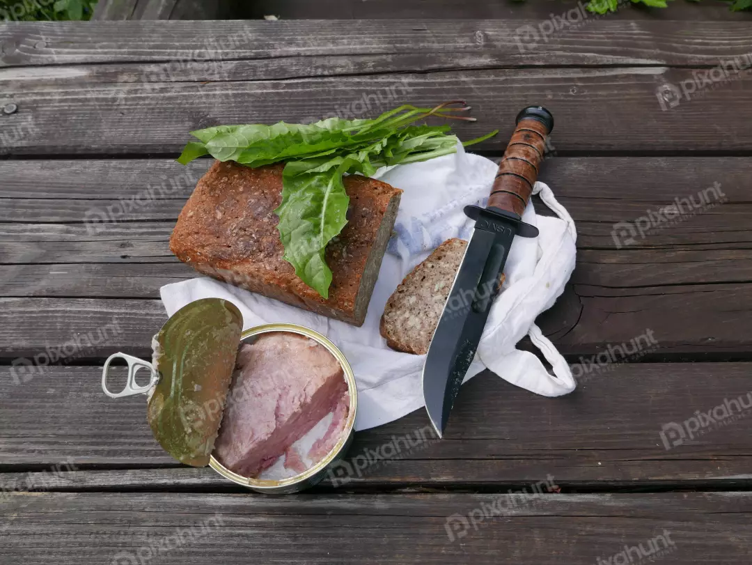 Outdoor Survival Meal: Canned Meat, Rustic Bread, Wild Greens, Military Knife
